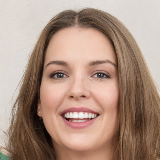 Joyful white young-adult female with long  brown hair and green eyes