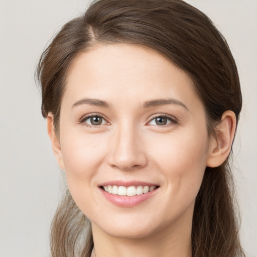 Joyful white young-adult female with long  brown hair and brown eyes