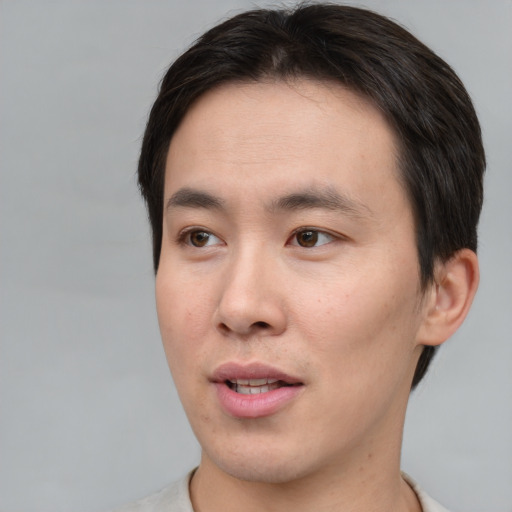 Joyful asian young-adult male with short  brown hair and brown eyes