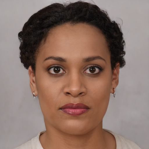 Joyful black young-adult female with short  brown hair and brown eyes
