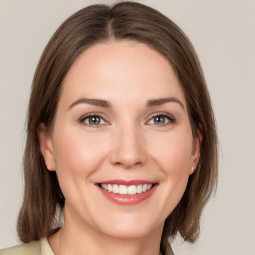 Joyful white young-adult female with medium  brown hair and grey eyes