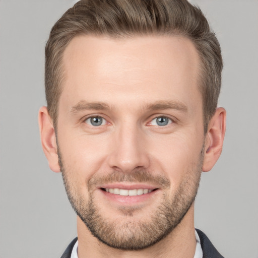 Joyful white young-adult male with short  brown hair and grey eyes