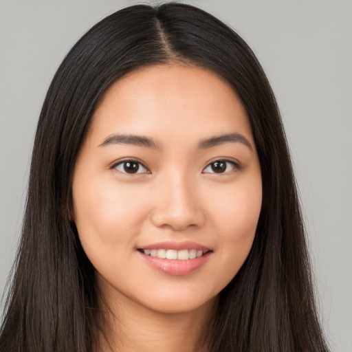 Joyful latino young-adult female with long  brown hair and brown eyes