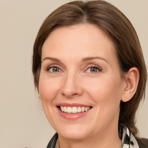 Joyful white adult female with medium  brown hair and blue eyes