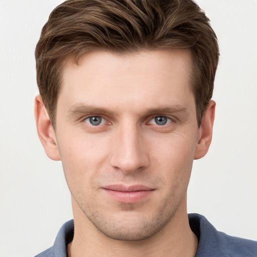 Joyful white young-adult male with short  brown hair and grey eyes