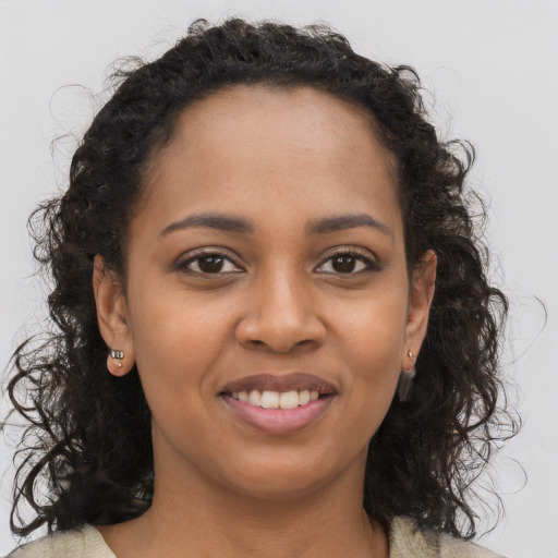 Joyful black young-adult female with long  brown hair and brown eyes