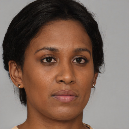 Joyful black young-adult female with medium  brown hair and brown eyes