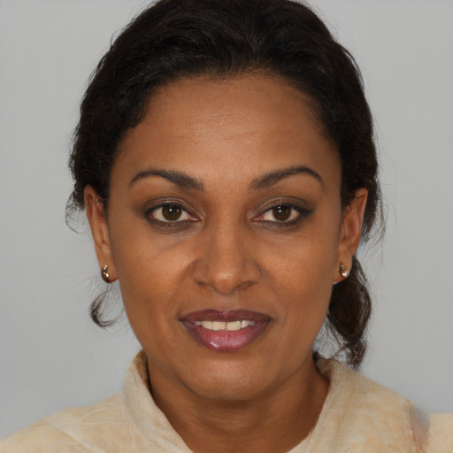 Joyful black adult female with medium  brown hair and brown eyes