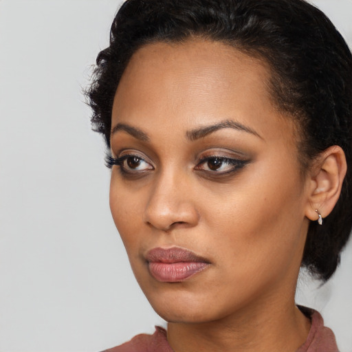 Joyful black young-adult female with medium  black hair and brown eyes