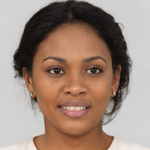 Joyful black young-adult female with medium  brown hair and brown eyes