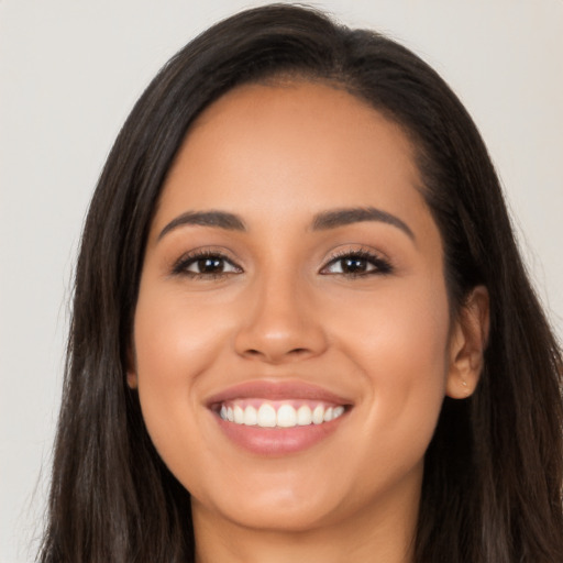 Joyful latino young-adult female with long  brown hair and brown eyes