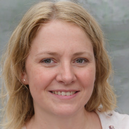 Joyful white young-adult female with medium  brown hair and blue eyes