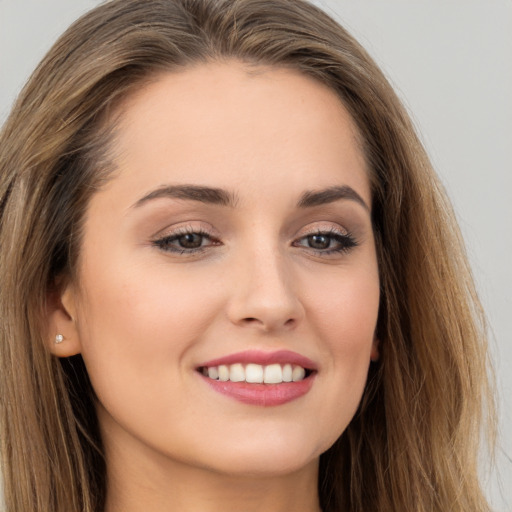 Joyful white young-adult female with long  brown hair and brown eyes