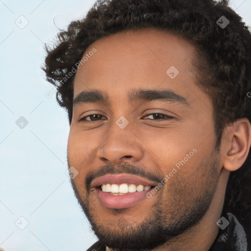 Joyful black young-adult male with short  brown hair and brown eyes