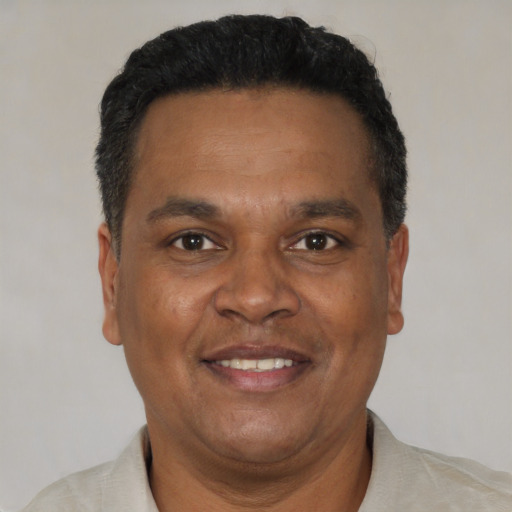 Joyful black adult male with short  brown hair and brown eyes