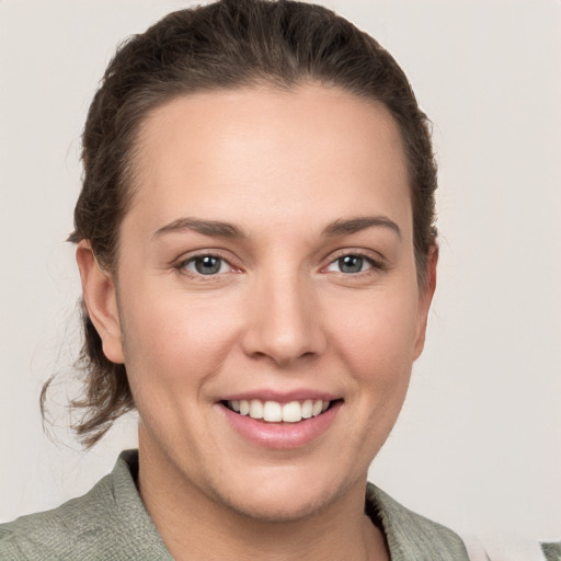 Joyful white young-adult female with medium  brown hair and grey eyes