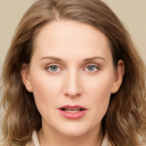 Joyful white young-adult female with long  brown hair and blue eyes