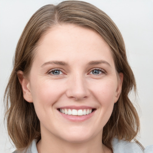 Joyful white young-adult female with medium  brown hair and grey eyes