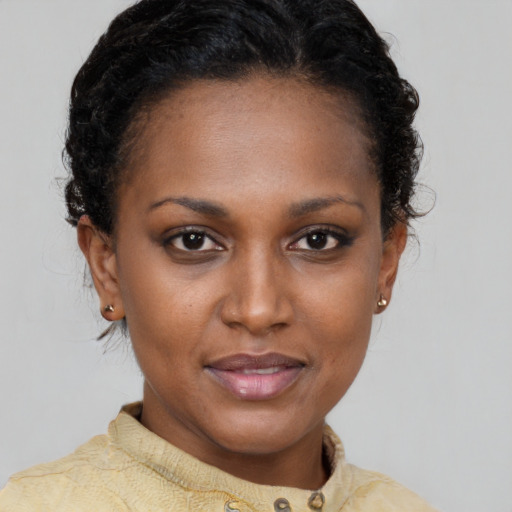 Joyful black young-adult female with short  brown hair and brown eyes