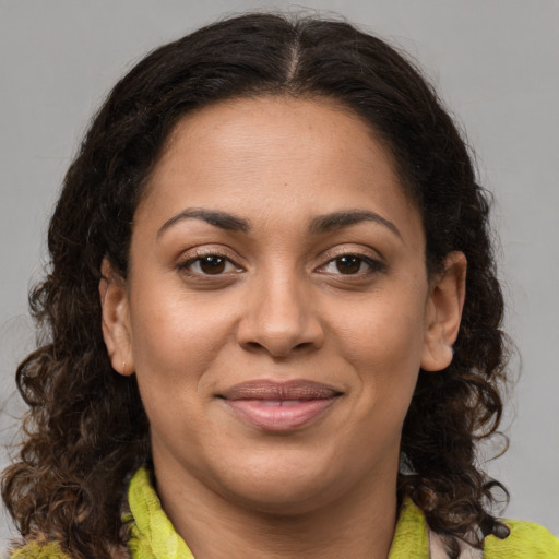 Joyful latino adult female with medium  brown hair and brown eyes