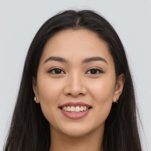 Joyful latino young-adult female with long  brown hair and brown eyes