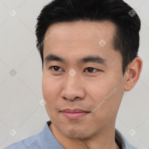 Joyful asian young-adult male with short  black hair and brown eyes