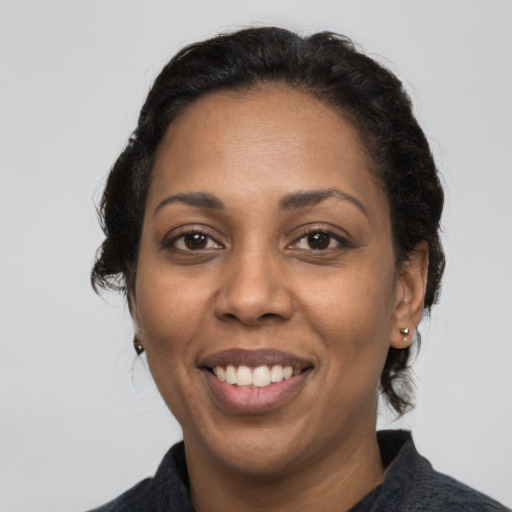 Joyful latino adult female with medium  black hair and brown eyes