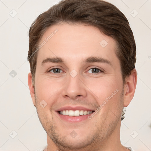 Joyful white young-adult male with short  brown hair and grey eyes