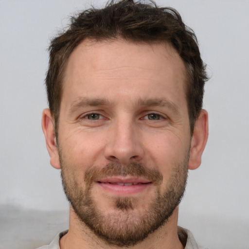 Joyful white adult male with short  brown hair and brown eyes