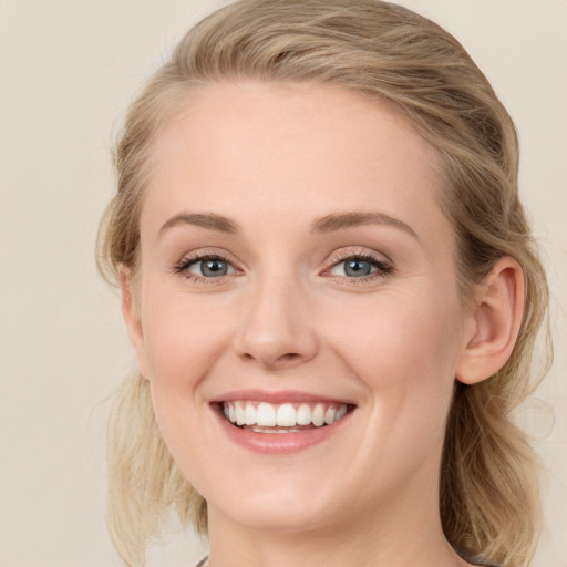 Joyful white young-adult female with medium  brown hair and blue eyes