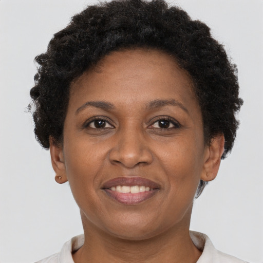Joyful black adult female with short  brown hair and brown eyes