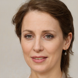 Joyful white adult female with medium  brown hair and green eyes