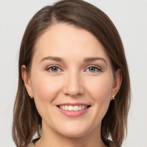 Joyful white young-adult female with medium  brown hair and grey eyes