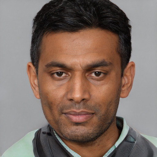 Neutral latino adult male with short  black hair and brown eyes