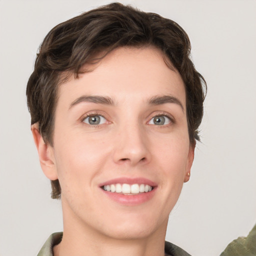 Joyful white young-adult female with short  brown hair and grey eyes