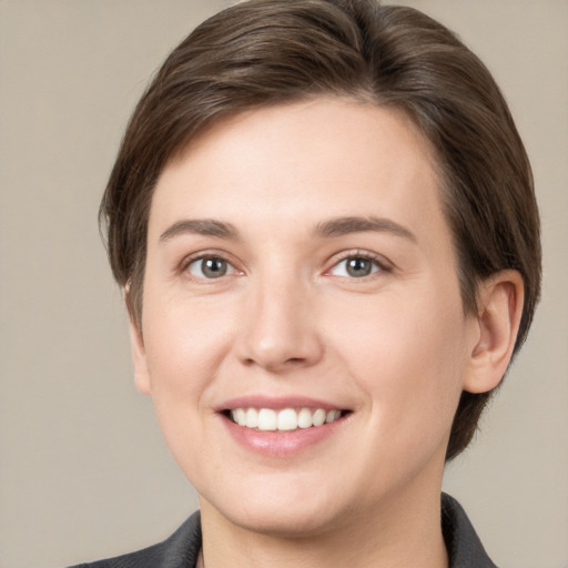 Joyful white young-adult female with short  brown hair and grey eyes