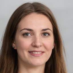 Joyful white young-adult female with long  brown hair and grey eyes