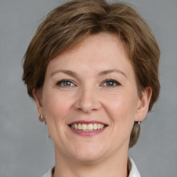 Joyful white adult female with medium  brown hair and grey eyes