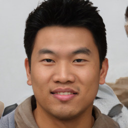 Joyful asian young-adult male with short  black hair and brown eyes