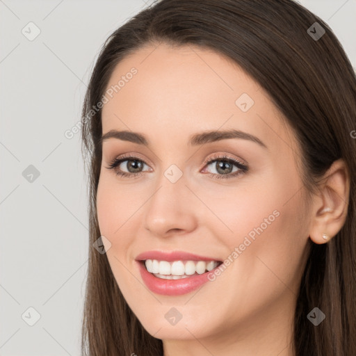 Joyful white young-adult female with long  brown hair and brown eyes