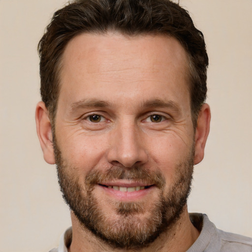 Joyful white adult male with short  brown hair and brown eyes