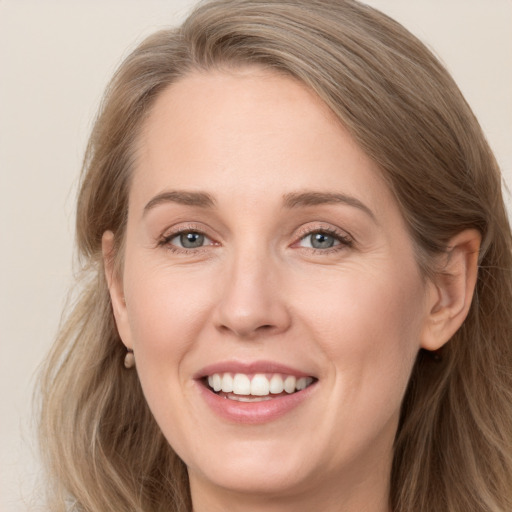 Joyful white adult female with long  brown hair and grey eyes