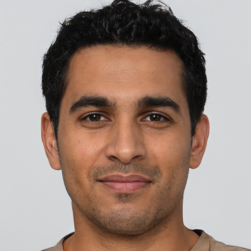 Joyful latino young-adult male with short  black hair and brown eyes