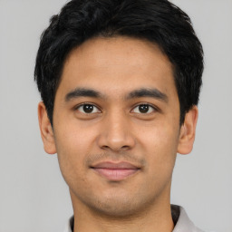 Joyful latino young-adult male with short  black hair and brown eyes