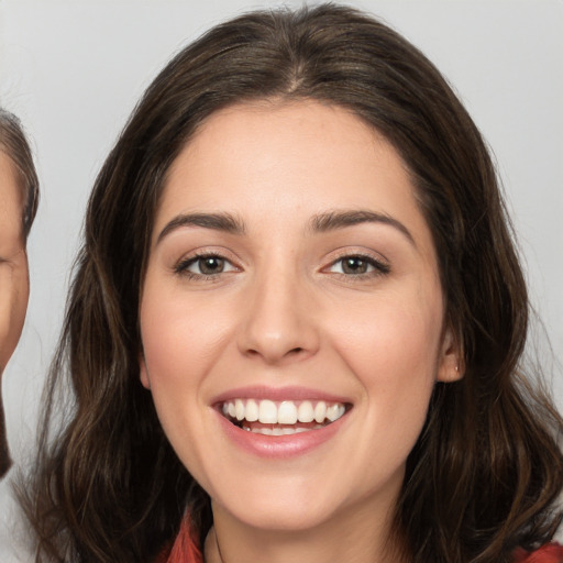 Joyful white young-adult female with long  brown hair and brown eyes