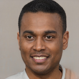 Joyful black young-adult male with short  black hair and brown eyes