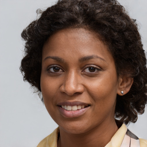 Joyful black young-adult female with long  brown hair and brown eyes