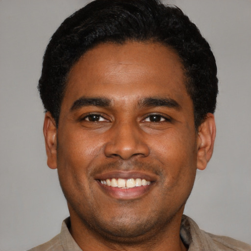 Joyful latino young-adult male with short  black hair and brown eyes