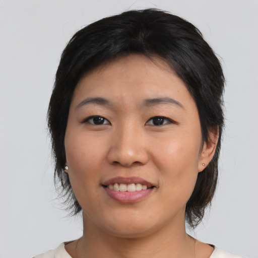 Joyful asian young-adult female with medium  brown hair and brown eyes