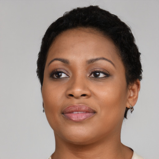 Joyful black young-adult female with short  brown hair and brown eyes